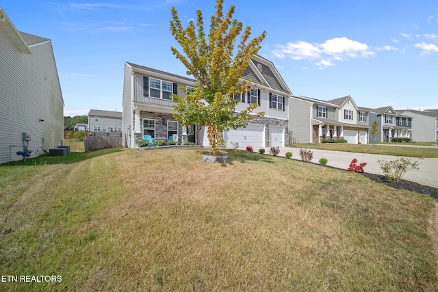 view of front facade featuring a garage, central air condition unit, and a front yard