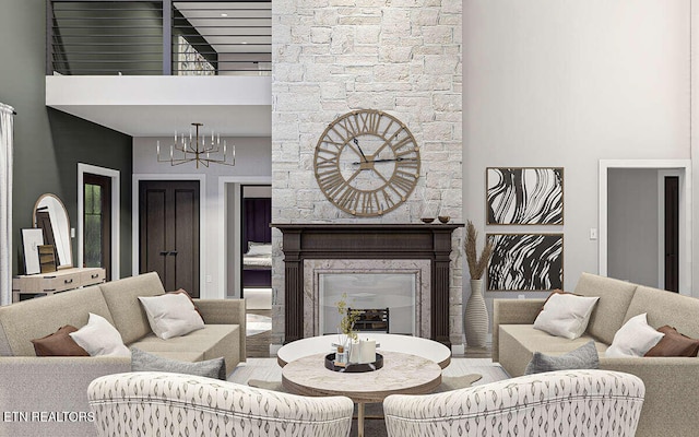 living room featuring a large fireplace, a towering ceiling, and a notable chandelier