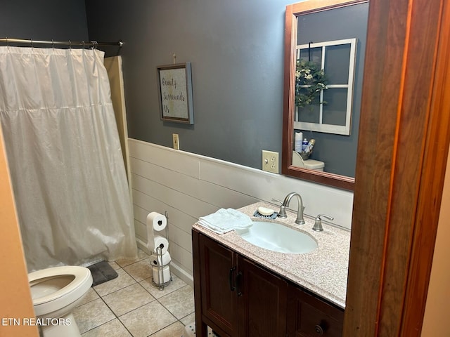 bathroom featuring walk in shower, tile patterned floors, toilet, vanity, and tile walls