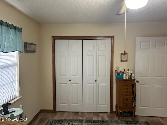 bedroom with wood-type flooring, a textured ceiling, a closet, and ceiling fan