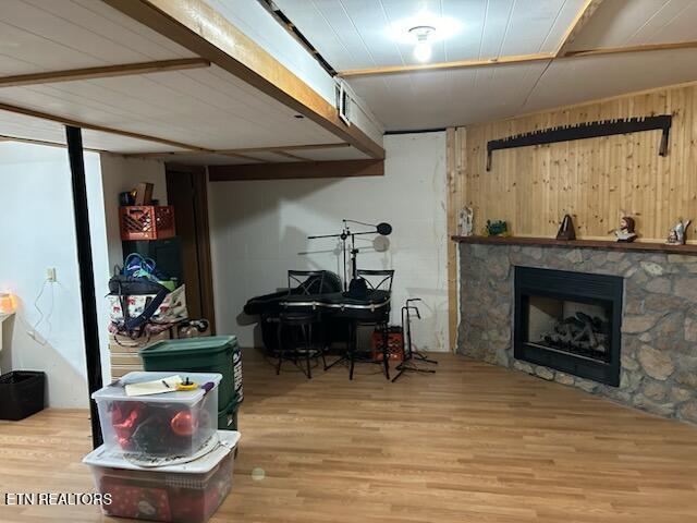 basement featuring a stone fireplace and hardwood / wood-style flooring