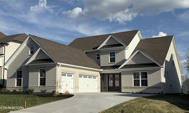 view of front facade with brick siding, french doors, metal roof, and a standing seam roof