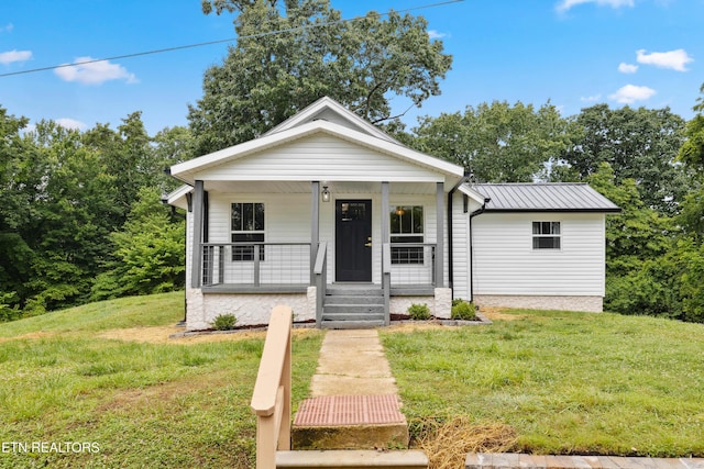 bungalow-style home featuring covered porch and a front lawn