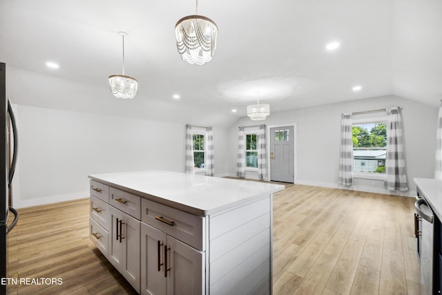 kitchen featuring lofted ceiling, plenty of natural light, hanging light fixtures, and a notable chandelier