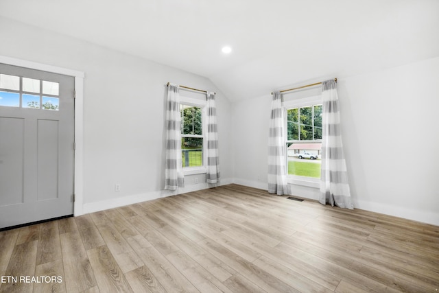 foyer entrance with lofted ceiling and light hardwood / wood-style flooring