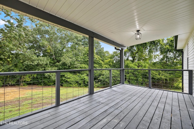 wooden deck featuring a lawn