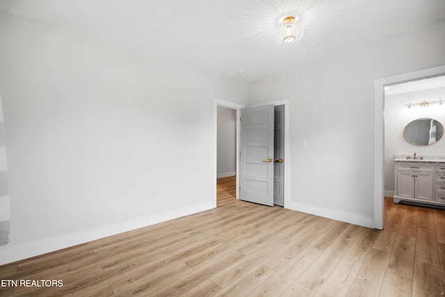 unfurnished bedroom with light hardwood / wood-style floors and ensuite bath