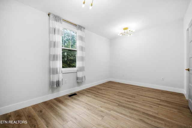 unfurnished room with hardwood / wood-style flooring