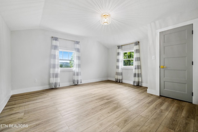 unfurnished living room with light hardwood / wood-style flooring, a wealth of natural light, and lofted ceiling