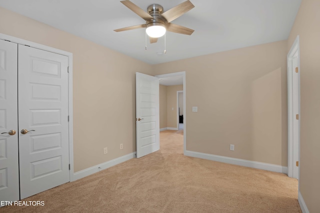 unfurnished bedroom featuring a closet, light colored carpet, and ceiling fan