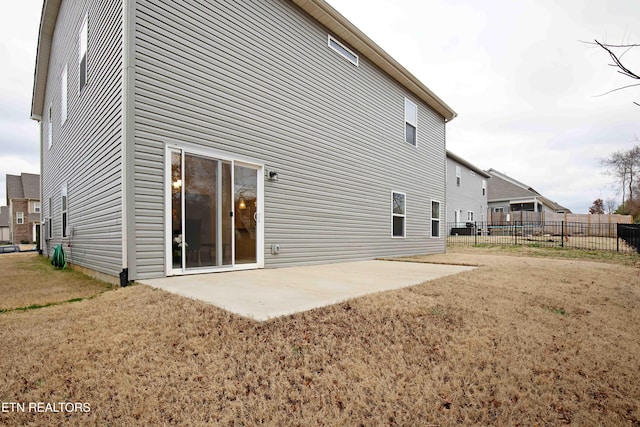 back of property featuring a patio, fence, and a lawn