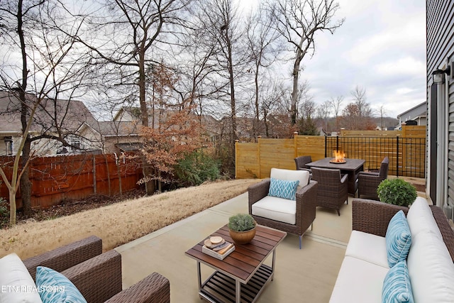 view of patio with an outdoor living space with a fire pit and fence