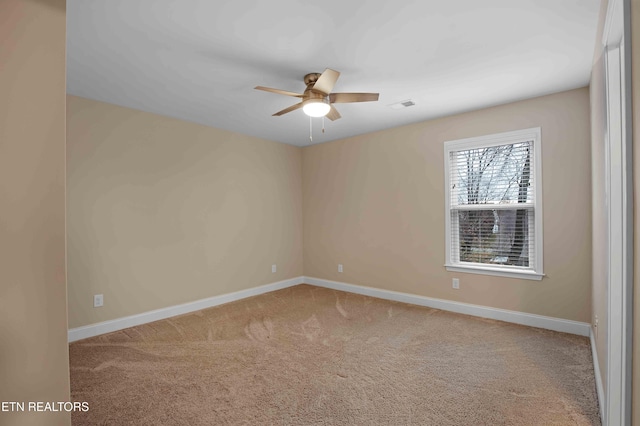 unfurnished room with light colored carpet, ceiling fan, visible vents, and baseboards