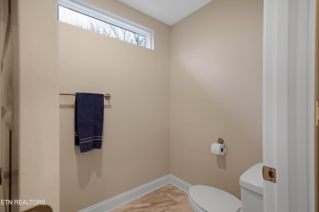 bathroom featuring toilet and baseboards