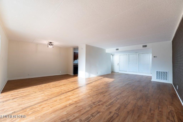 unfurnished living room featuring a textured ceiling and hardwood / wood-style floors