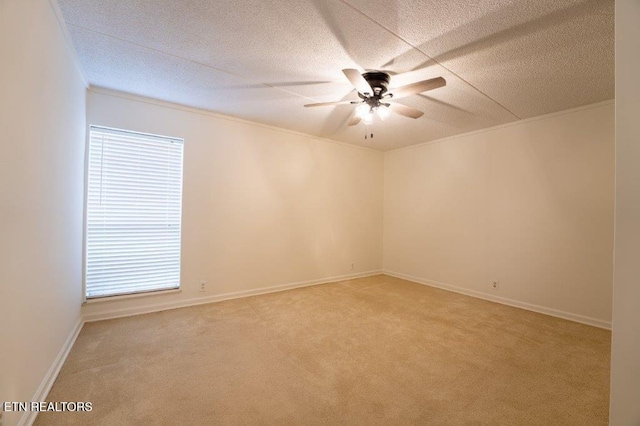 empty room with ceiling fan, crown molding, carpet floors, and a textured ceiling