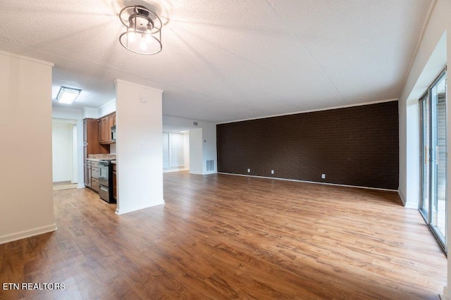 unfurnished living room featuring a textured ceiling and light hardwood / wood-style flooring