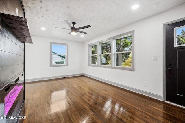 interior space with a textured ceiling, hardwood / wood-style flooring, and ceiling fan