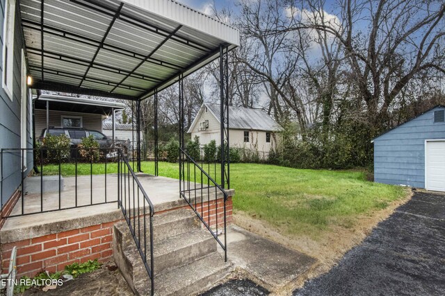 view of yard featuring a carport, a garage, and an outbuilding