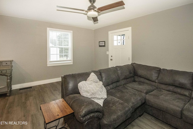 living room featuring ceiling fan and dark hardwood / wood-style flooring