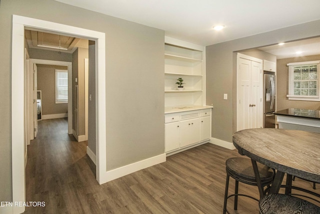 dining area with dark hardwood / wood-style floors and built in features