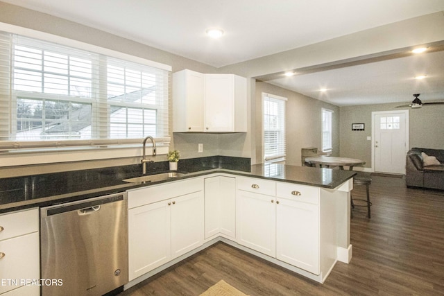 kitchen with kitchen peninsula, stainless steel dishwasher, ceiling fan, sink, and white cabinets