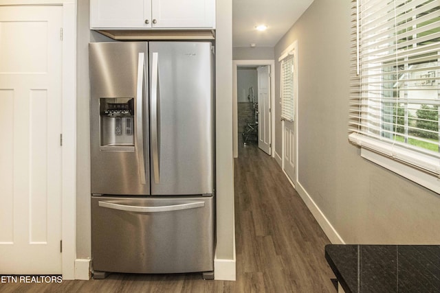 kitchen featuring white cabinets, plenty of natural light, stainless steel fridge, and dark wood-type flooring