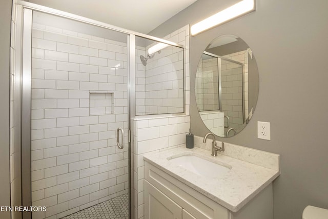 bathroom featuring toilet, vanity, and walk in shower