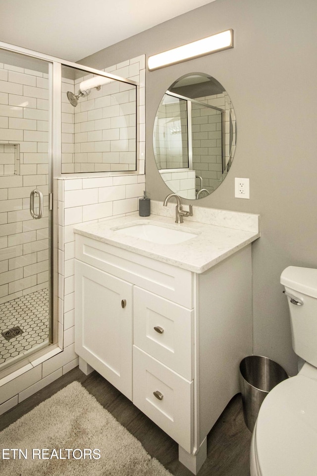 bathroom with vanity, hardwood / wood-style flooring, toilet, and walk in shower