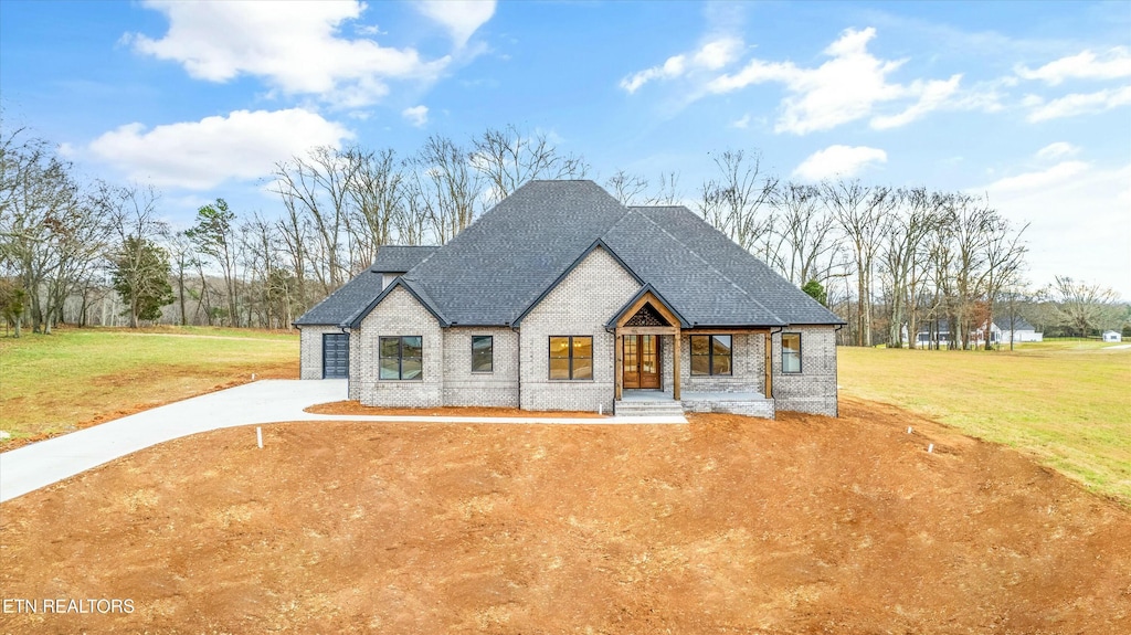 french country style house with a front yard and a porch