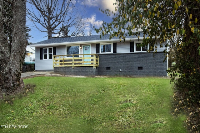 back house at dusk featuring a yard and a wooden deck