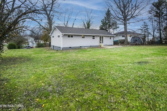 rear view of property featuring a lawn