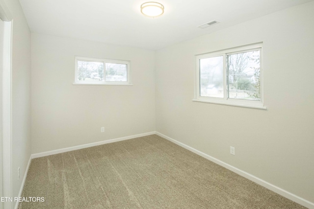 unfurnished room featuring a wealth of natural light and carpet