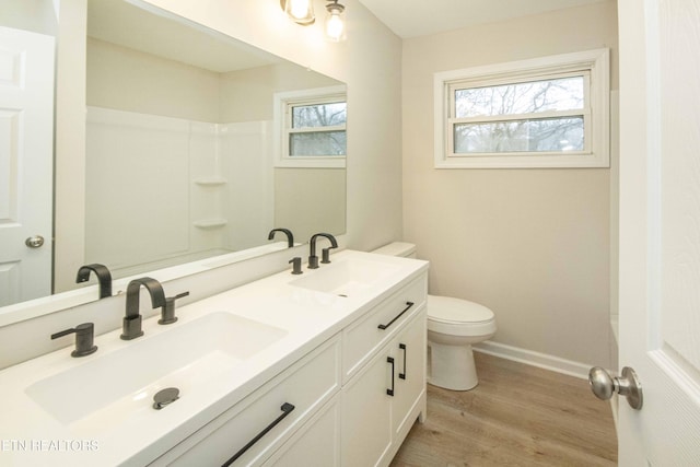 bathroom with hardwood / wood-style flooring, vanity, and toilet