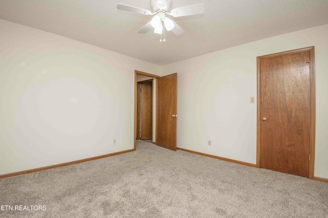 carpeted spare room with ceiling fan and a textured ceiling