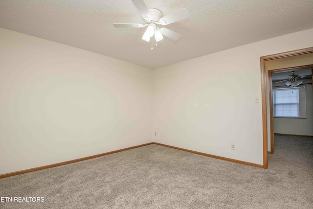 carpeted spare room featuring a textured ceiling and ceiling fan