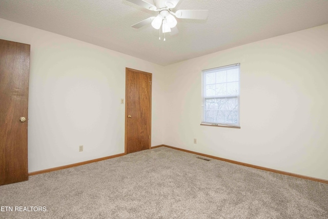 spare room with ceiling fan, carpet floors, and a textured ceiling