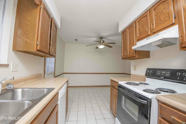 kitchen with white appliances, sink, ceiling fan, light tile patterned floors, and a textured ceiling