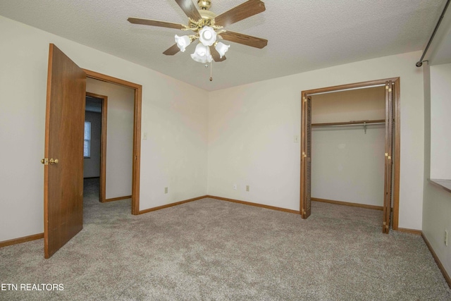 unfurnished bedroom featuring a textured ceiling, a closet, light colored carpet, and ceiling fan