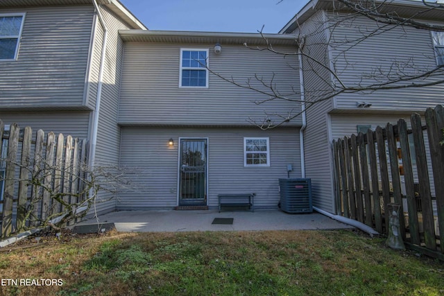 rear view of property featuring a lawn, central air condition unit, and a patio