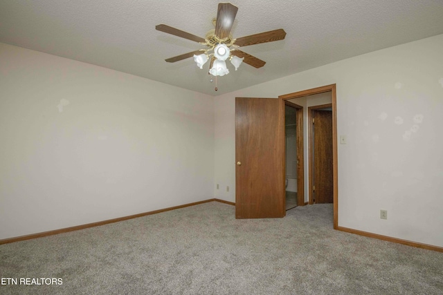 carpeted empty room featuring ceiling fan and a textured ceiling