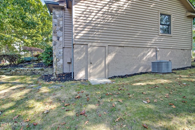 view of property exterior with a yard and central AC unit