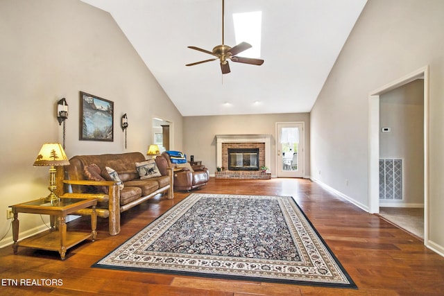 living room with hardwood / wood-style floors, ceiling fan, high vaulted ceiling, and a brick fireplace