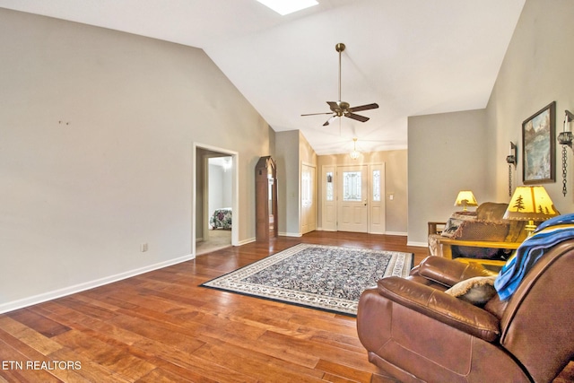 living room with ceiling fan, hardwood / wood-style floors, and vaulted ceiling