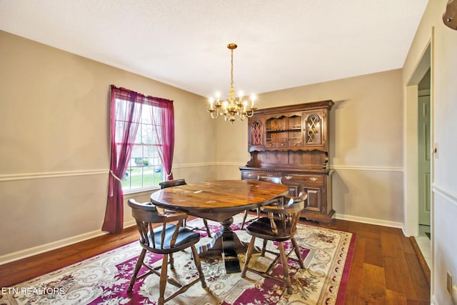 dining space with dark hardwood / wood-style floors and a notable chandelier