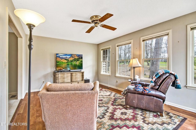 living room featuring wood-type flooring and ceiling fan