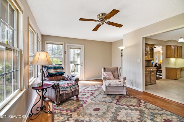 living area with ceiling fan and light hardwood / wood-style floors