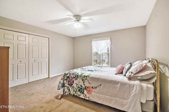 carpeted bedroom featuring ceiling fan, a textured ceiling, and a closet