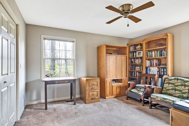 living area with light colored carpet and ceiling fan