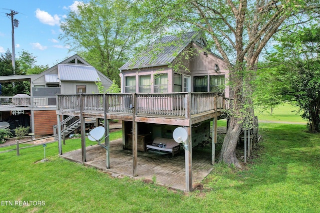 rear view of property featuring a lawn and a wooden deck